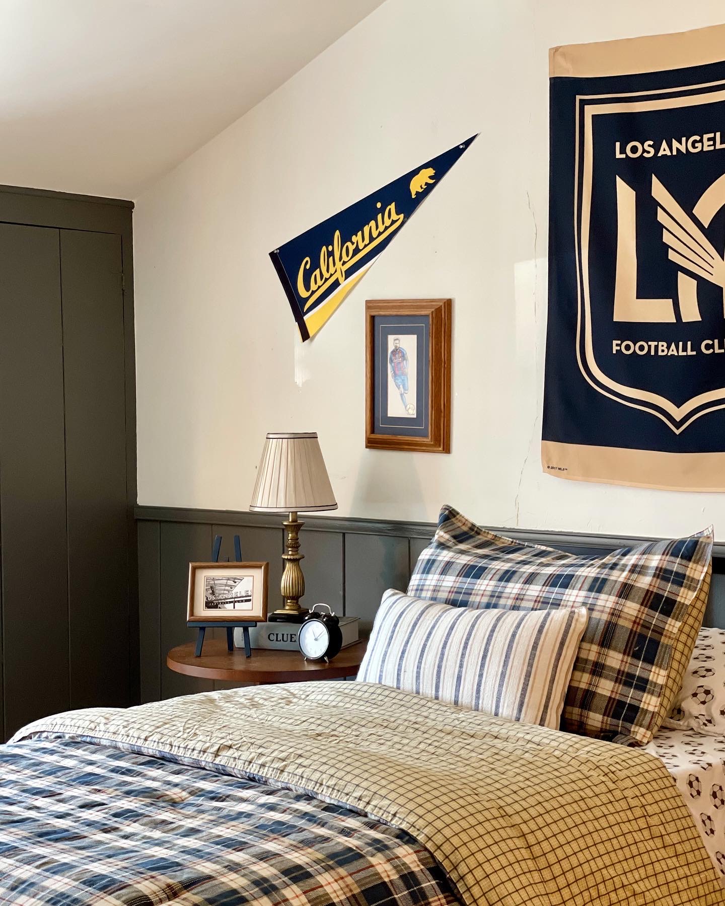 Boys soccer room, kids soccer themed room, kendall charcoal benjamin moore, dark gray paint, black paint, shiplap walls, dunn edwards swiss coffee paint, built in closets, window in middle of closet, wooden woven shades, interior dormer window, vintage rug, laminate floors, plaid bedding, LAFC themed room, modern traditional kids room, shiplap wainscotting, camp themed room